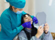 A woman is getting her teeth cleaned by a dentist