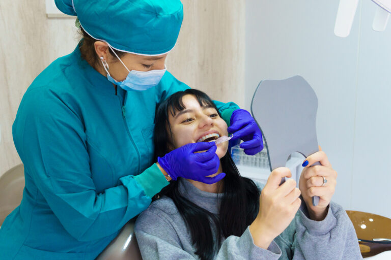 A woman is getting her teeth cleaned by a dentist